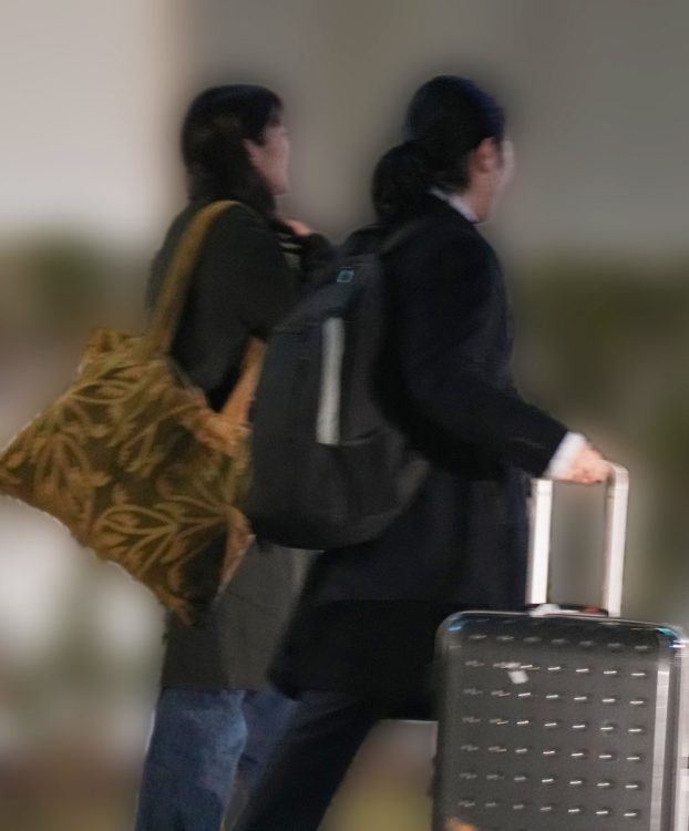 スーツケースを引く小室圭氏