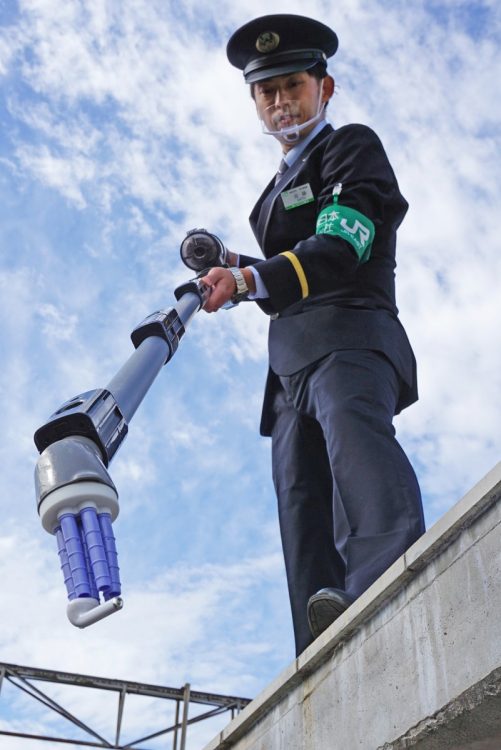 掃除機型回収機を使ってワイヤレスイヤホンを回収するJR東日本社員（イメージ、時事通信フォト）