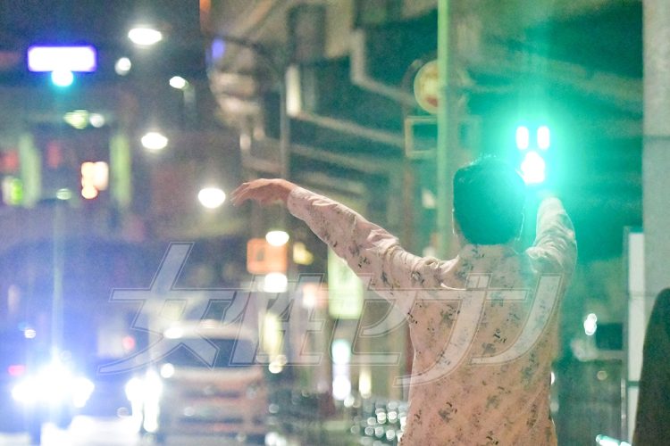 大きく手を振りタクシーを呼ぶ