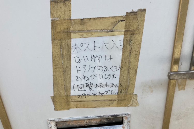 玄関ドアには違和感ある張り紙が
