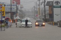 台風10号の影響で、冠水した道路で立ち往生する車両(時事通信フォト)