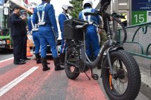 ペダル付き電動バイク「モペット」の取り締まりをする警察官。11月1日午後、東京都新宿区(時事通信フォト)