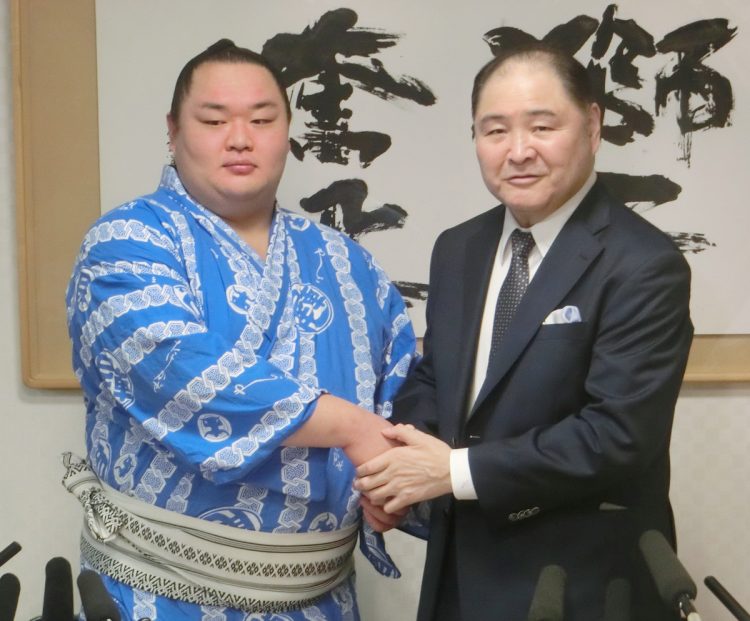 友風と握手をする前・尾車親方。2018年の新十両昇進時(時事通信フォト)