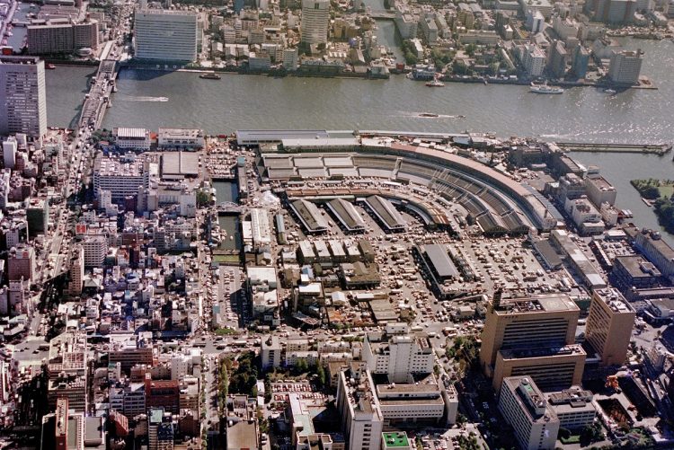 空から見た築地市場(東京中央卸売市場)扇のように独特のカーブを描く外観は鉄道の貨物線路の長さを確保するためだった。1990年11月(時事通信フォト)