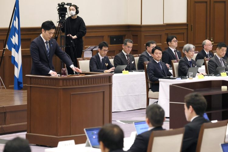 兵庫県議会本会議で、自身の疑惑を調べる調査特別委員会(百条委員会)の奥谷謙一委員長(左端)の報告を聞く斎藤元彦知事(右から5人目)。3月5日(時事通信フォト)