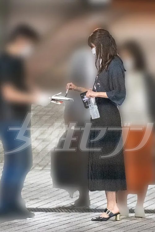 片手にはスマホと水を持ちながら、ファンのペンをおもむろに受け取る