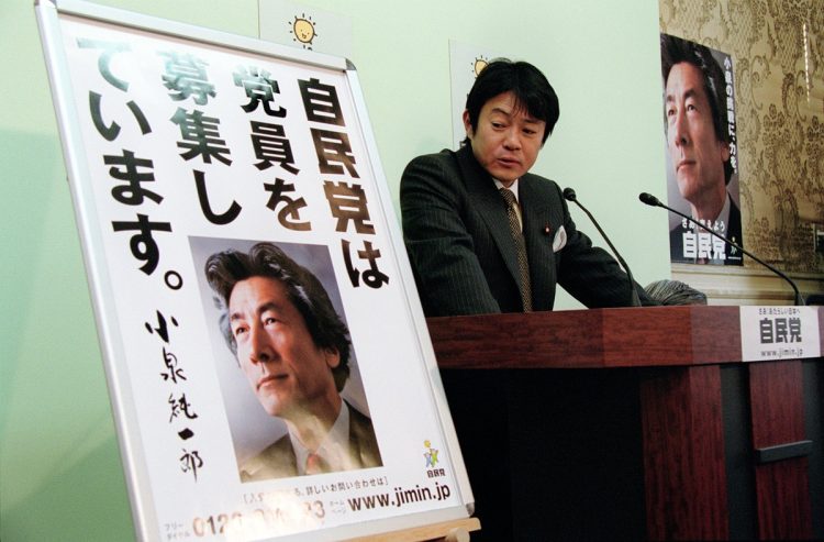 2001年10月、党員獲得のため小泉純一郎首相を前面に押し出したポスターを披露する自民党の中川昭一広報本部長(当時)。党員数減少はすでに問題となっていた(時事通信フォト)
