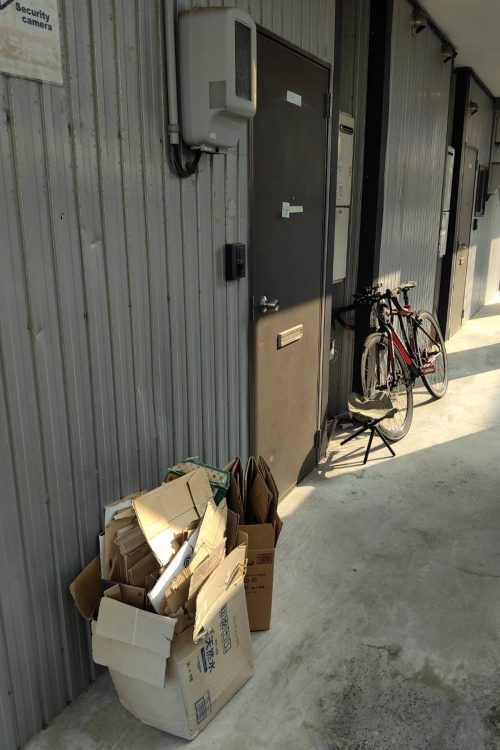 しばらく不在だったのか、部屋前には段ボールのゴミが大量に置かれていた