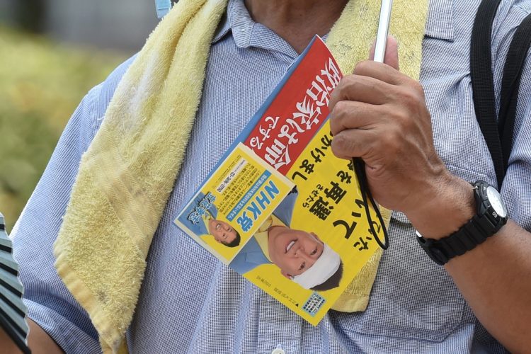 ポスターを持ち立花孝志氏の演説を聞く