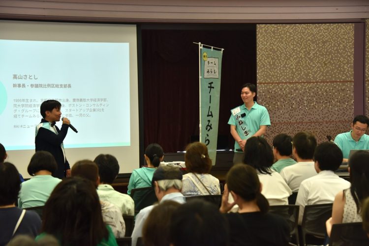 東京都北区王子で開催したチームみらいの演説会。集まった支援者を前に高山聡史幹事長(左)と峰島侑也氏(右)が政策を説明中(2025年7月写真撮影:小川裕夫)