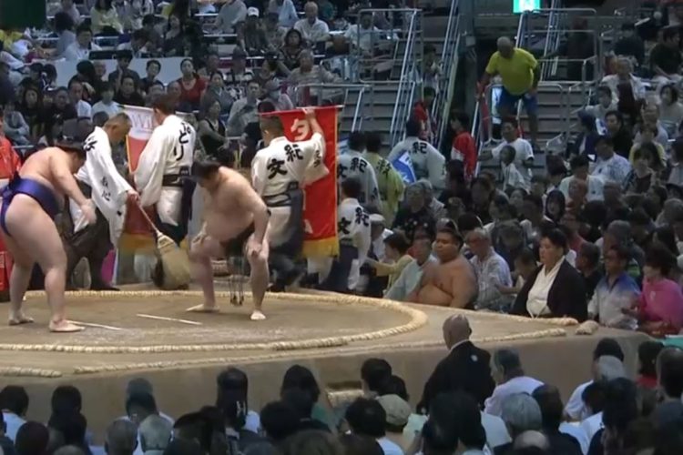 名古屋場所14日目の西の溜席の最前列、「着物美人」として知られる女性がピンクの鮮やかな洋服姿で登場