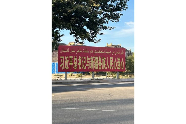 「習近平総書記と新疆の各民族人民は心と心が繋がっている」と書かれた看板（撮影／西谷格）