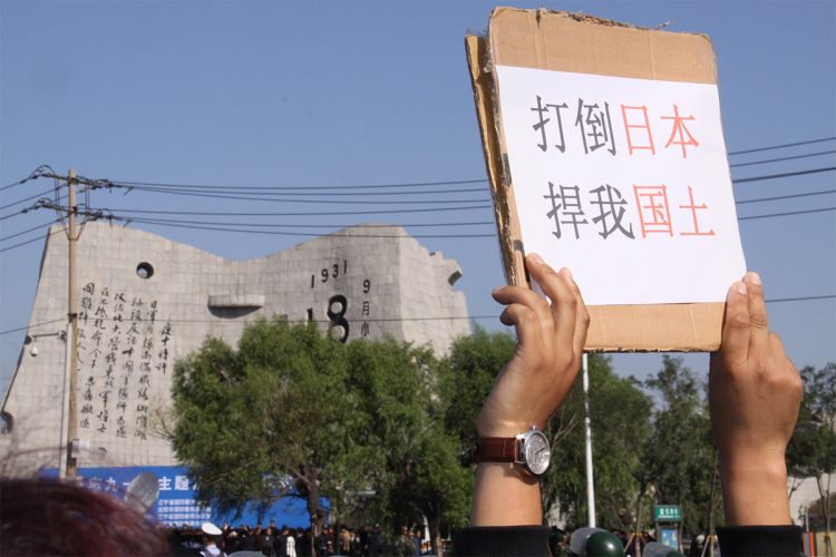 柳条湖事件81年の記念式典会場の外で掲げられた「日本を打倒せよ。わが国土を守れ」と書かれたプラカード(2012年9月18日撮影、時事通信フォト)
