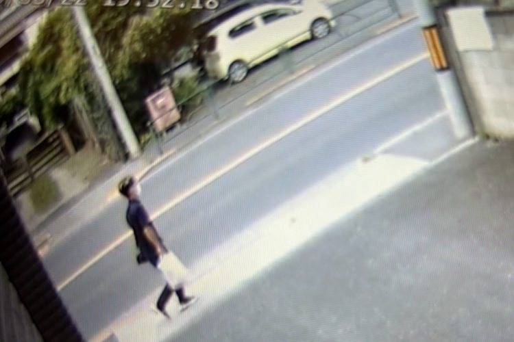 逮捕直前の容疑者。手には白い袋を携えている（住民提供）