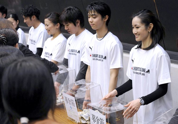 チャリティー演技会を終え、募金を呼びかける羽生。向かって右は荒川静香(2011年4月) (写真/共同通信社)