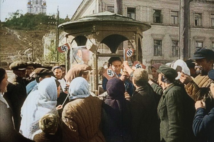 スターリンの圧政に苦しんだウクライナの人々はヒトラーを解放者として歓迎した。配られるナチ・ドイツの旗を我先にと手にとる人々(C)NHK