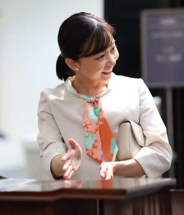 和柄のスカーフがシンプルコーデのアクセントに(2025年10月10日、撮影/JMPA)