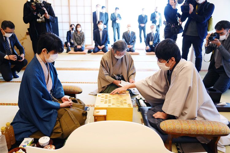 第35期竜王戦7番勝負第3局で封じ手を指す広瀬章人八段(右)と藤井聡太竜王。中央は立会人の青野照市九段(2022年10月29日撮影、時事通信フォト)