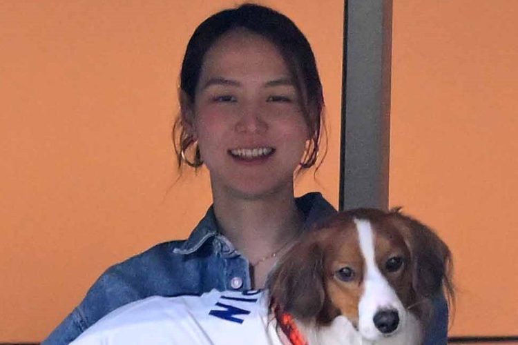 デコピンを抱えて試合を観戦する真美子さん(時事通信フォト)