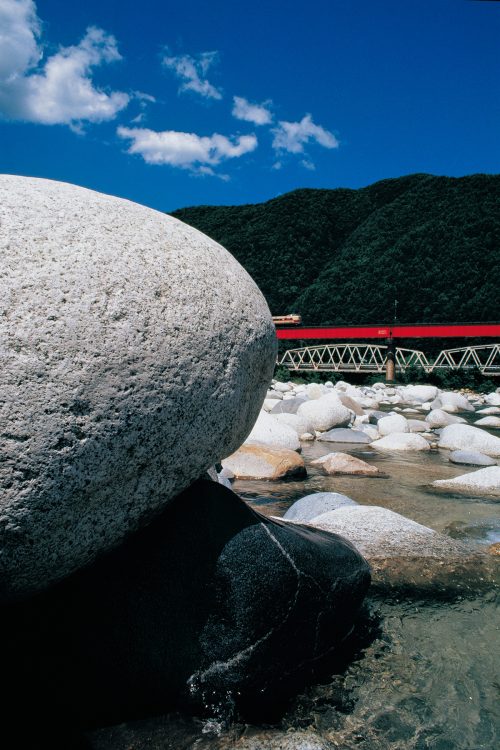 丸い岩から少しだけ姿を見せる381系特急「しなの」。ユーモラスな構成だ。中央本線須原〜大桑間。1991年8月