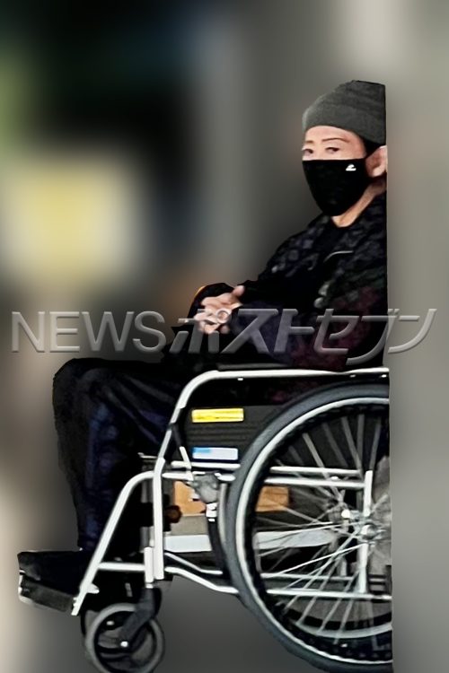 両手を組み、お洒落なヴィトンの上着を着用していた