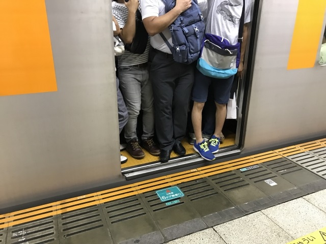 満員電車で周囲の人と腕が触れるのも恐れるように