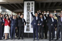 選挙本部の看板前で気勢を上げる安倍首相(共同通信社)