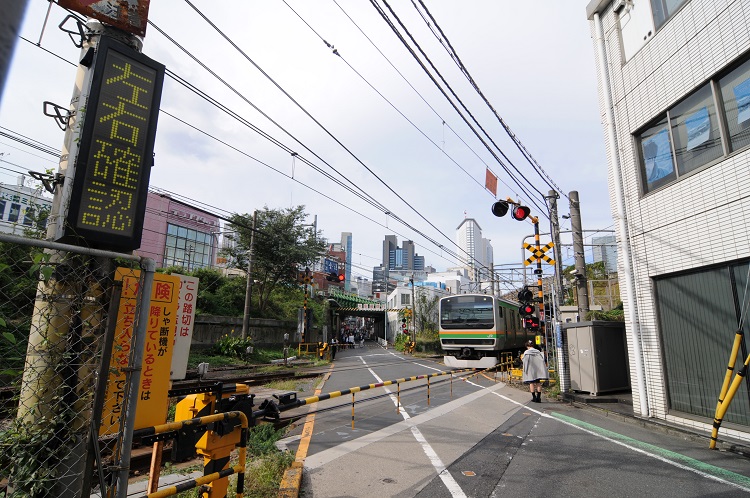 湘南新宿ラインの電車が通過中の青山街道踏切。前方に見えるのが山手線の高架、右手に見えるのが中央・総武線の高架。