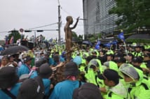 「徴用工像」をソウルの日本大使館に向けて動かす反日デモ参加者たち(AFP=時事)