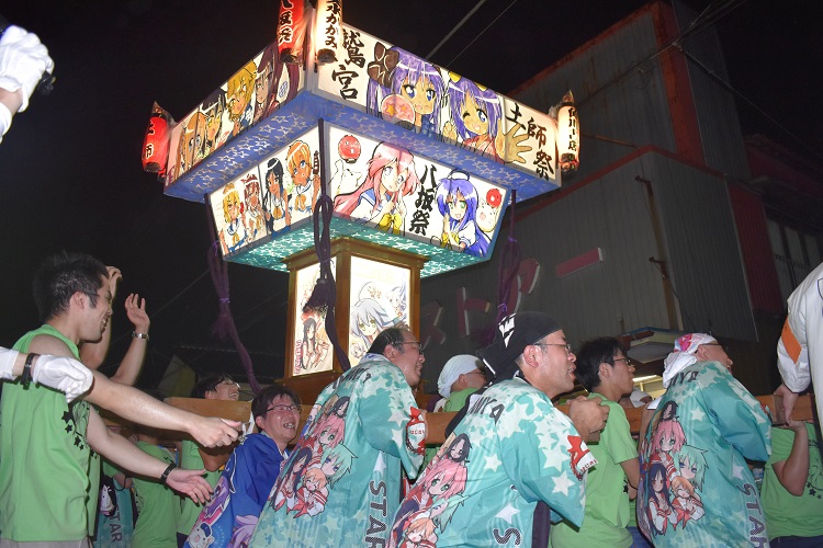 埼玉県の旧鷲宮町は同地が舞台のアニメ「らき☆すた」ファンが多く訪れる。祭りでは、キャラクターを描いたみこしをファンが担ぐ様子も恒例に（時事通信フォト）